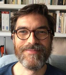 Portrait de Nicolas Donin, un homme souriant, portant des lunettes.