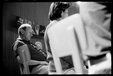 Photo noir et blanc de gens assis sur des chaises