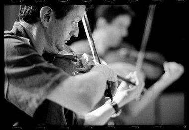Photo noir et blanc d'un musicien de profil qui joue de son instrument