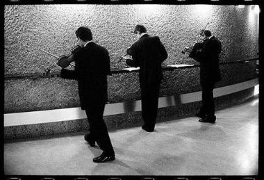 Photo noir et blanc de trois hommes de dos qui jouent de leurs instruments