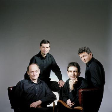 Photo du quatuor sine nomine, deux des membres sont assis et les deux autre sont debout derrière eux
