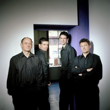 Photo du Quatuor Sine Nomine : les quatre hommes se tiennent debout avec des vêtements noirs