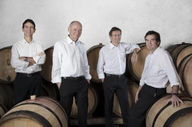 Photo du Quatuor Sine Nomine : les quatre hommes, en chemise blanche et pantalon noir, se tiennent debout au milieu des tonneaux.